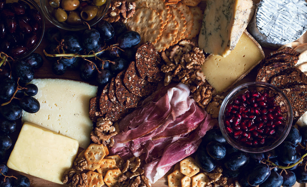 Fresh mets, cheeses, fruits, and dips forming a charcuterie board.  