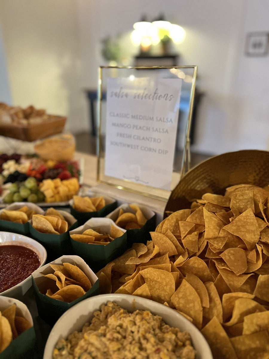 Chips and salsa displayed on a large table.  