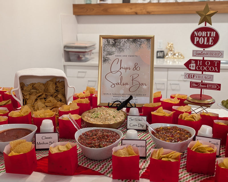 Chips and salsa bar setup with various dips and tortilla chips on a table.