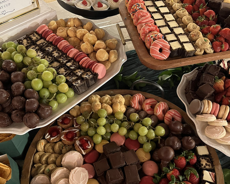 Assorted dessert platter with fruits, cookies, and pastries on a table.