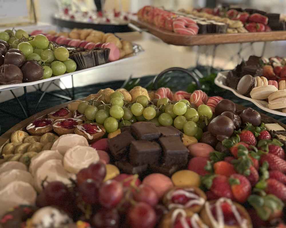 Assorted pastries and fruits on a tiered dessert stand with blurred background.  Photo of a dessert buffet.  