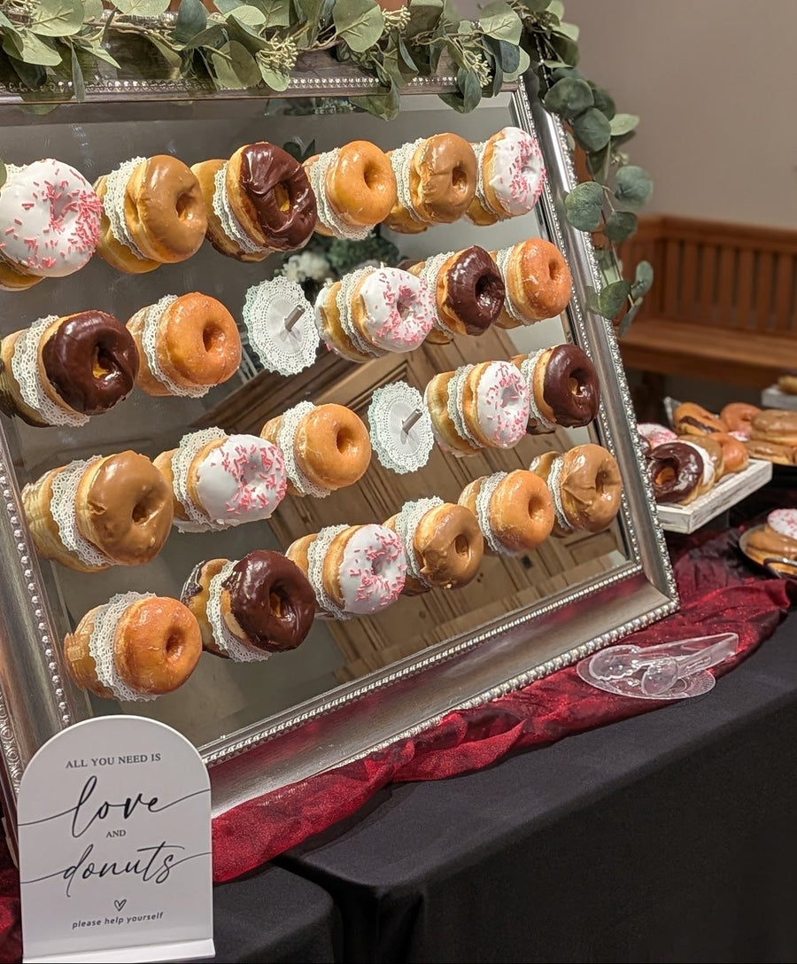 Large mirror with a variety of donuts displayed to grab and go.  