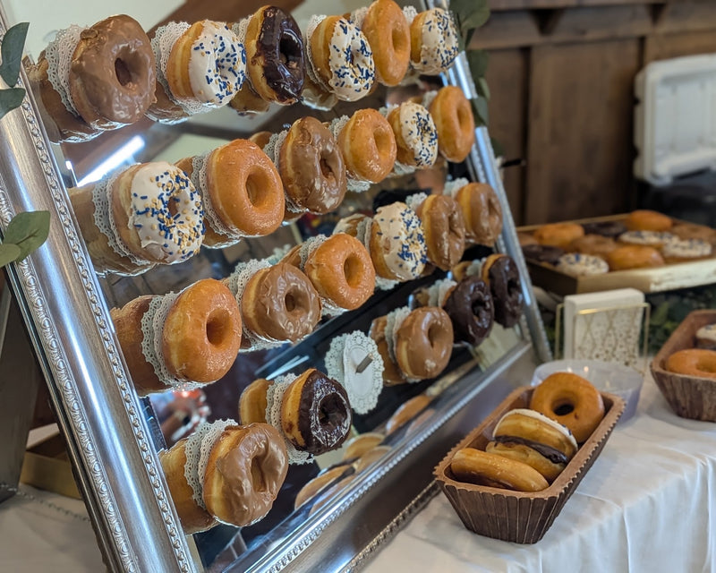 Large mirror with donuts hanging from pegs for guests to take one to eat.  