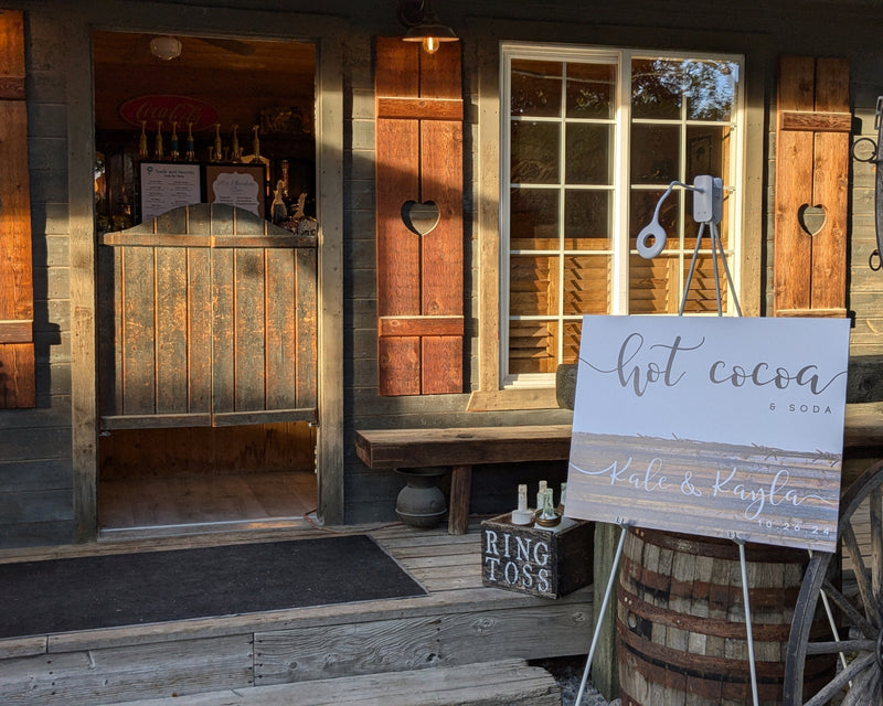 Wooden building entrance with a 'hot cocoa' sign and rustic decor.