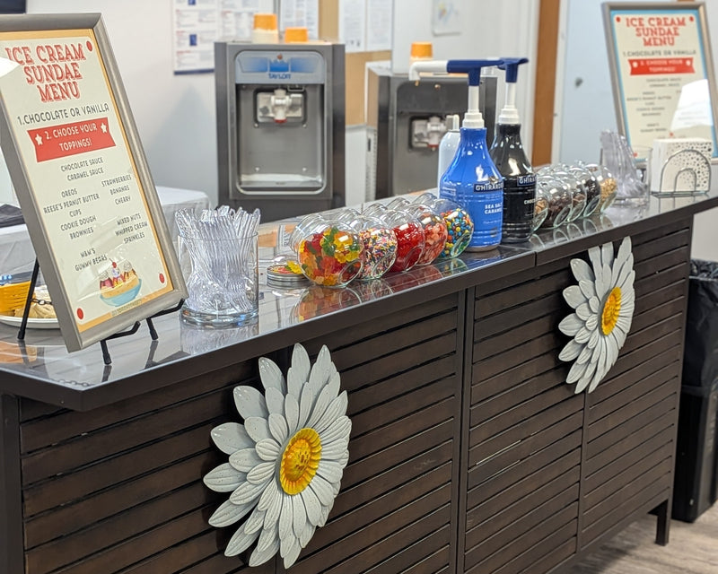 Ice cream sundae bar with menu and toppings in a casual setting