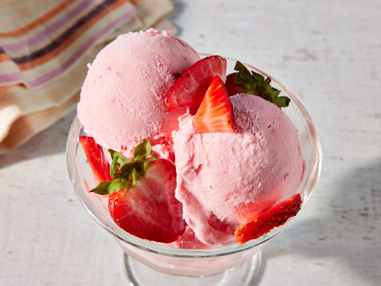 Dish of fresh ice cream topped with strawberries