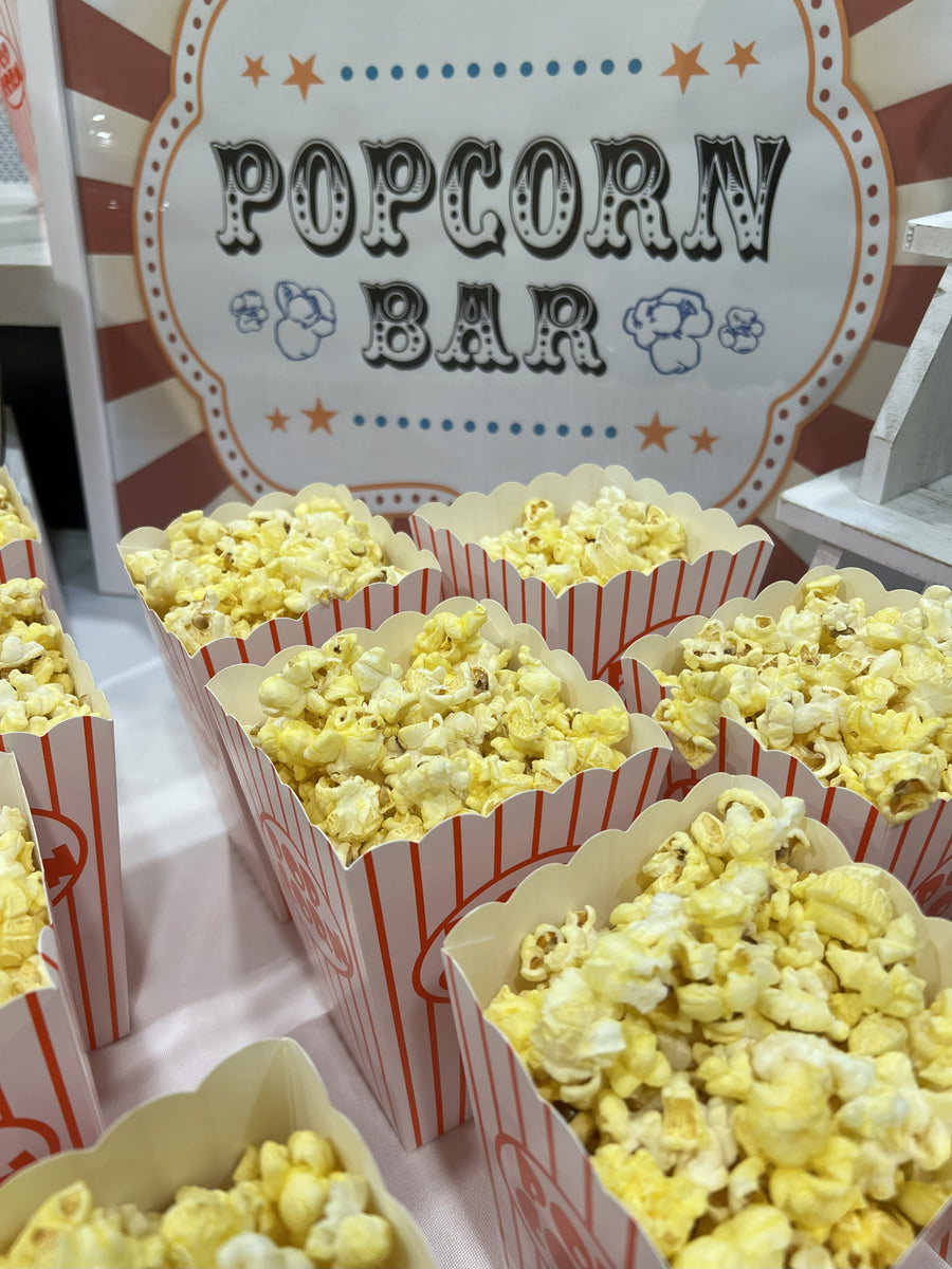 Popcorn bar with boxes of popcorn on a table displayed in red and white popcorn boxes.  