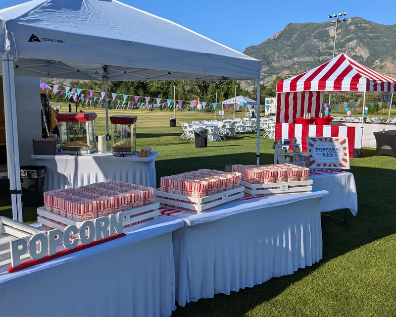Popcorn table under a white tent with a scenic background
